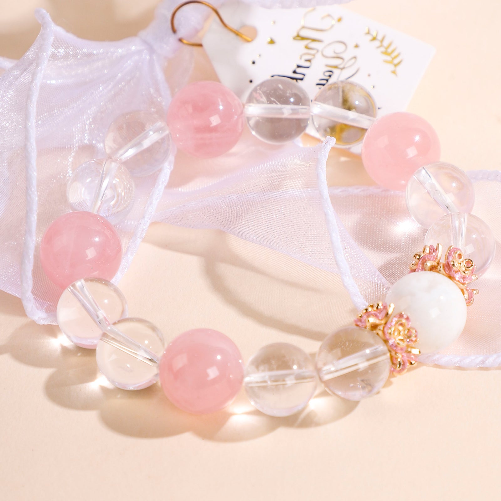 Minimalist bracelet featuring four pink beads and white crystal beads